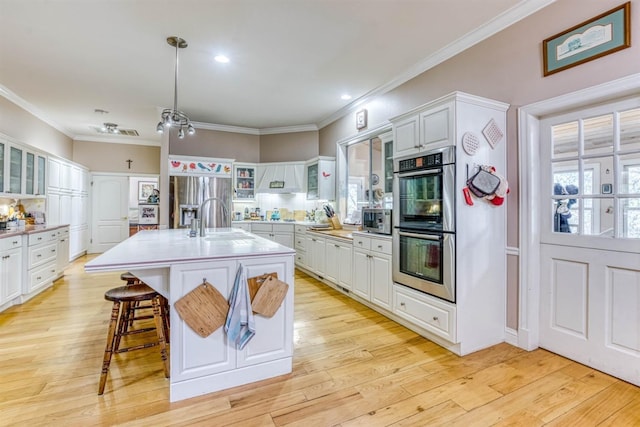 49521 Stillmeadow Dr, Oakhurst, CA 93644 - kitchen with glass insert cabinets, a sink, light countertops, appliances with stainless steel finishes, and light wood-style flooring