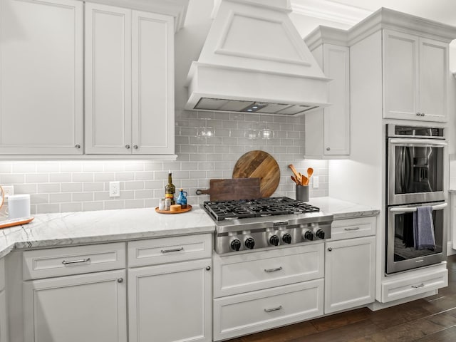 2567 E Sarazen, Fresno, CA 93730 - kitchen featuring stainless steel appliances, premium range hood, white cabinetry, dark wood-style floors, and tasteful backsplash