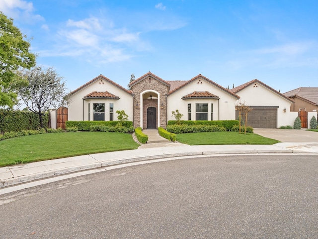 2567 E Sarazen, Fresno, CA 93730 - mediterranean / spanish house featuring stucco siding, driveway, a tile roof, and an attached garage