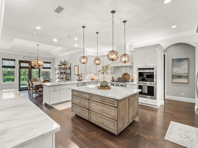2567 E Sarazen, Fresno, CA 93730 - kitchen with appliances with stainless steel finishes, a peninsula, backsplash, a center island, and a chandelier