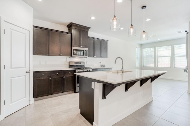 377 Wishon Way W, Madera, CA 93636 - kitchen featuring stainless steel appliances, a kitchen bar, a kitchen island with sink, light tile patterned floors, and light countertops