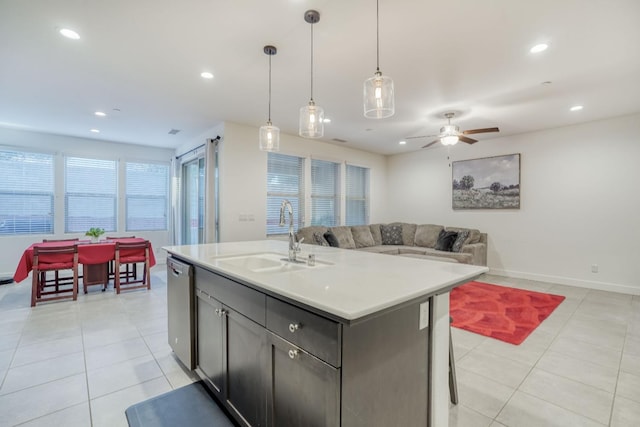 kitchen featuring a sink, stainless steel dishwasher, open floor plan, light tile patterned flooring, and recessed lighting