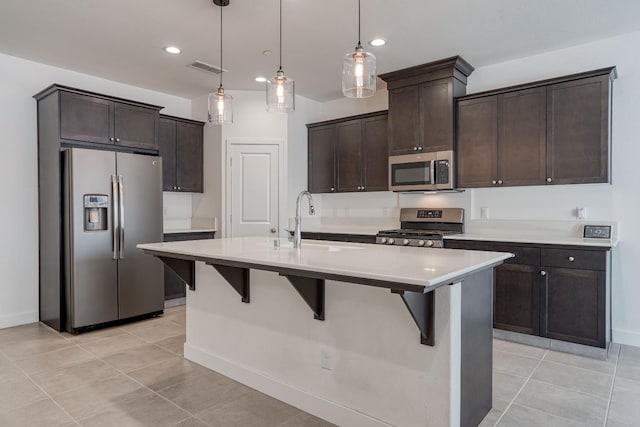 377 Wishon Way W, Madera, CA 93636 - kitchen featuring appliances with stainless steel finishes, dark brown cabinetry, a breakfast bar, light tile patterned floors, and recessed lighting