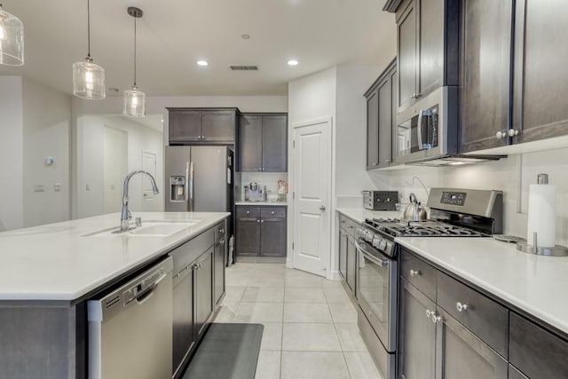 kitchen with stainless steel appliances, a sink, light tile patterned flooring, light countertops, and recessed lighting