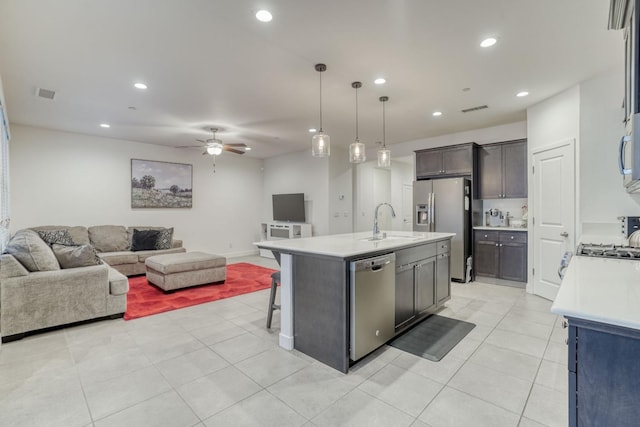 377 Wishon Way W, Madera, CA 93636 - kitchen featuring appliances with stainless steel finishes, open floor plan, light countertops, ceiling fan, and a center island with sink