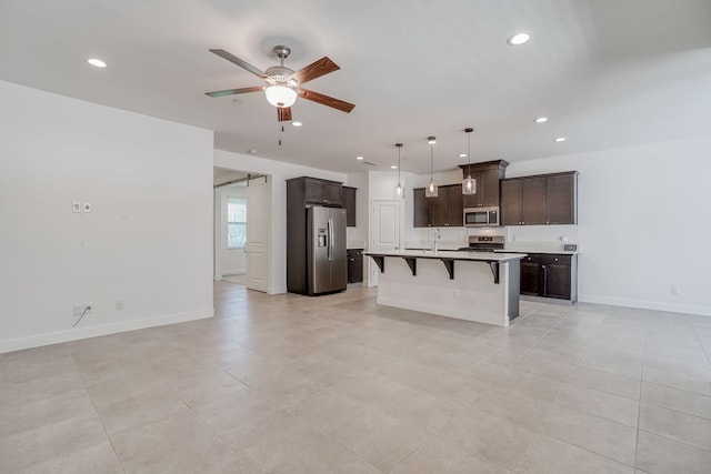 377 Wishon Way W, Madera, CA 93636 - kitchen featuring stainless steel appliances, open floor plan, a kitchen bar, a ceiling fan, and recessed lighting