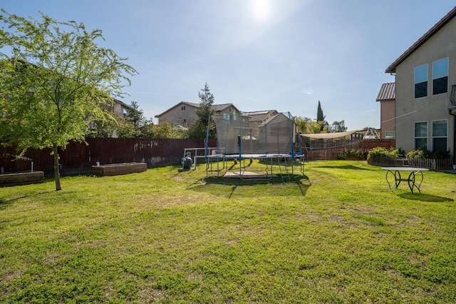 view of yard with a fenced backyard and a trampoline
