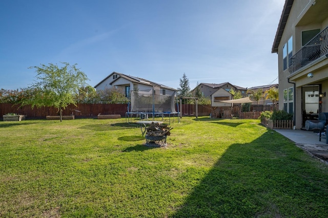 view of yard with a fenced backyard and a trampoline