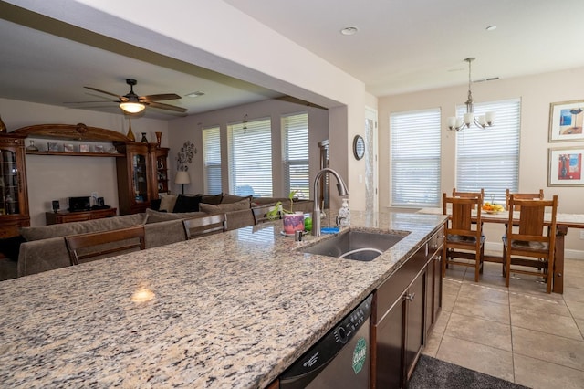 kitchen with plenty of natural light, light stone counters, dishwasher, and a sink