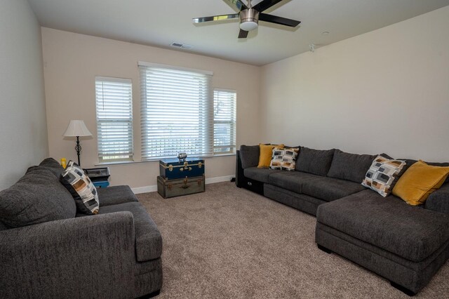 carpeted living area with baseboards, visible vents, and ceiling fan