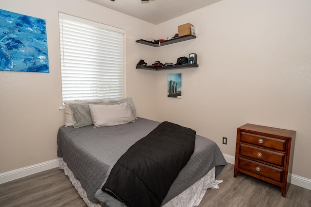 bedroom featuring baseboards and wood finished floors