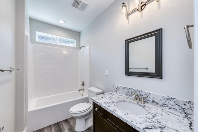 bathroom with shower / washtub combination, vanity, visible vents, toilet, and wood finished floors