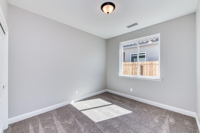 carpeted empty room with visible vents and baseboards