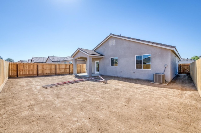 back of property with a patio, a fenced backyard, stucco siding, and central AC unit