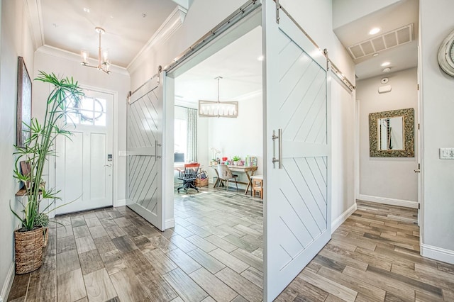 foyer entrance with a notable chandelier, visible vents, and a barn door
