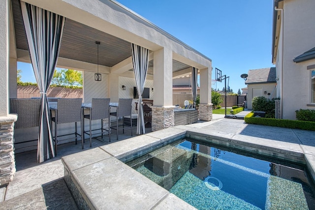 outdoor pool with outdoor wet bar, a patio area, and fence