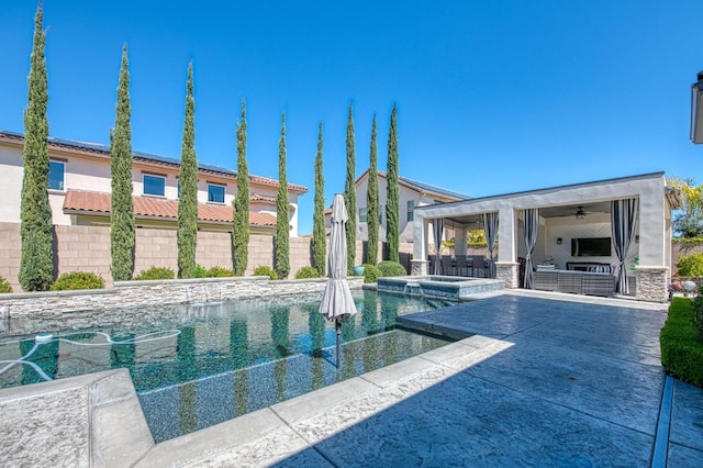 view of swimming pool featuring a patio area, fence, a ceiling fan, and a pool with connected hot tub