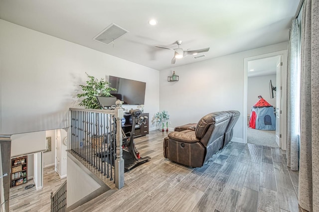 living room with visible vents, baseboards, a ceiling fan, and wood finished floors