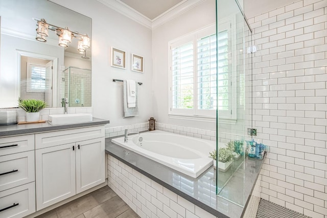 full bath featuring a garden tub, vanity, ornamental molding, wood finished floors, and a stall shower