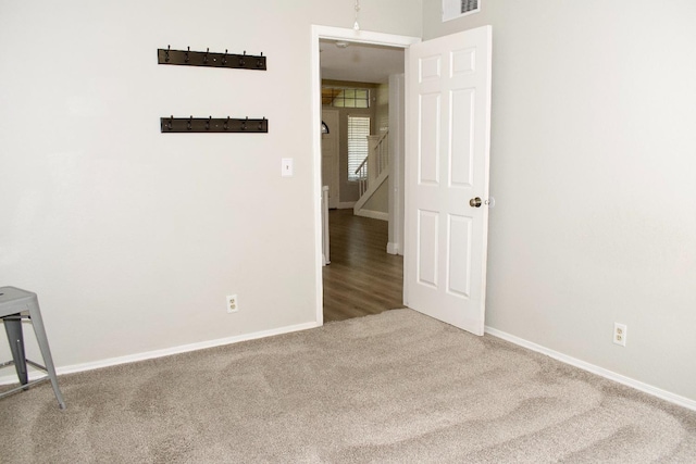 unfurnished room with baseboards, visible vents, and carpet flooring