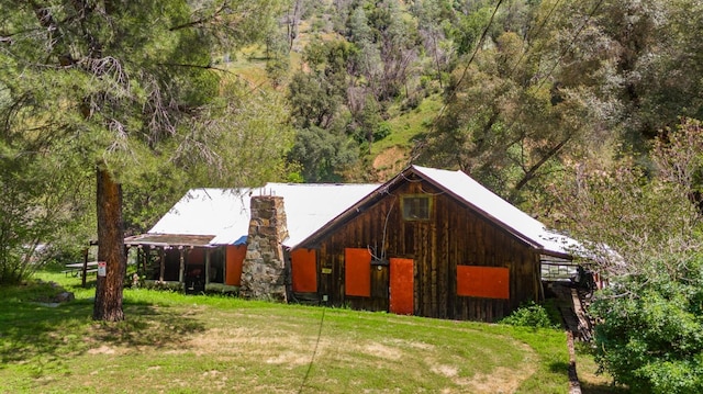 exterior space featuring a view of trees and a front yard