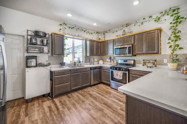 375 Amber Ln, Dinuba, CA 93618 - kitchen with light wood-type flooring, tasteful backsplash, light countertops, a sink, and stainless steel appliances