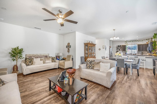 375 Amber Ln, Dinuba, CA 93618 - living room with light wood-style floors, ceiling fan with notable chandelier, and visible vents