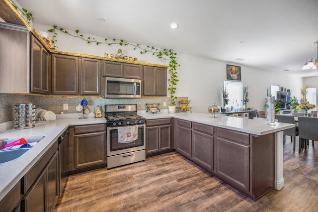 375 Amber Ln, Dinuba, CA 93618 - kitchen with light countertops, dark wood finished floors, a peninsula, and stainless steel appliances