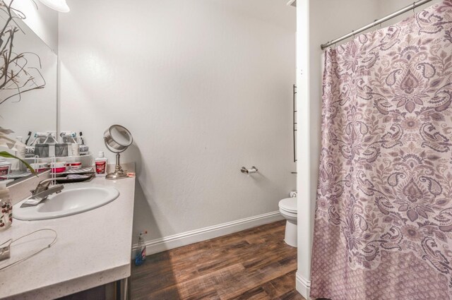 375 Amber Ln, Dinuba, CA 93618 - full bathroom with baseboards, a shower with shower curtain, toilet, vanity, and wood finished floors