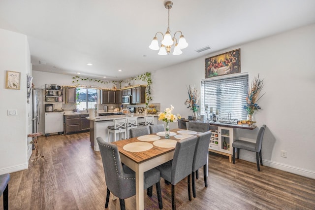 375 Amber Ln, Dinuba, CA 93618 - dining area featuring dark wood-type flooring, visible vents, baseboards, and a notable chandelier