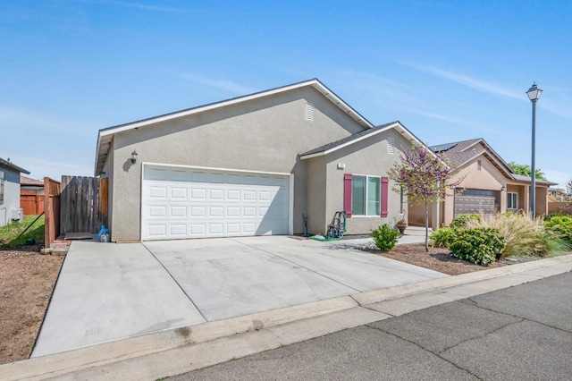 375 Amber Ln, Dinuba, CA 93618 - ranch-style home with fence, a garage, stucco siding, and concrete driveway