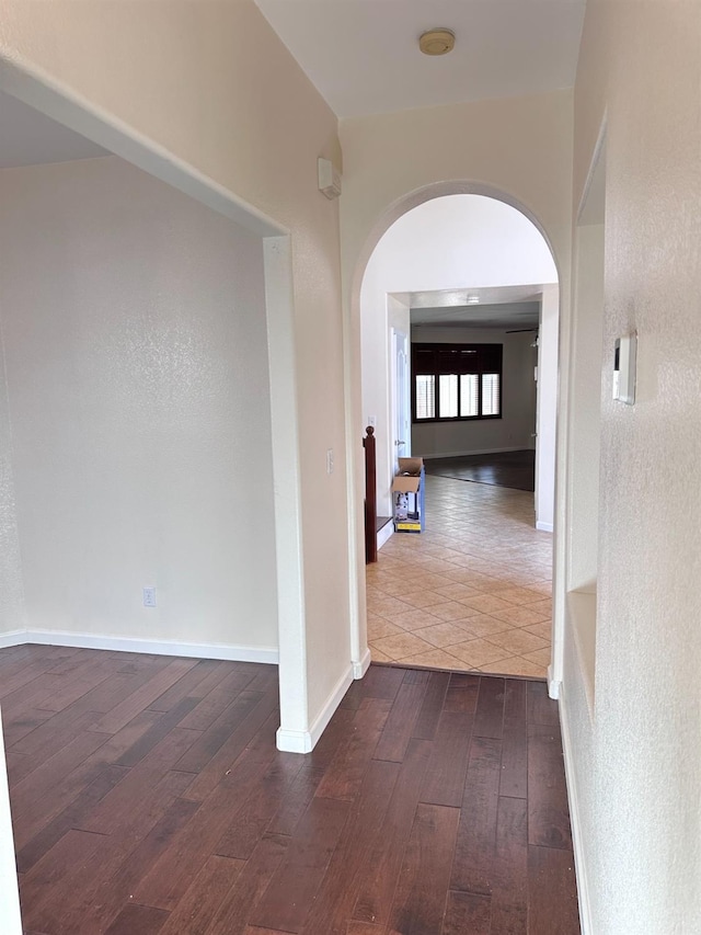 8352 N Shallot Way, Fresno, CA 93720 - hall with arched walkways, baseboards, and dark wood-style flooring