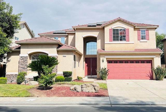 8352 N Shallot Way, Fresno, CA 93720 - mediterranean / spanish-style house featuring concrete driveway, a tiled roof, an attached garage, stucco siding, and solar panels