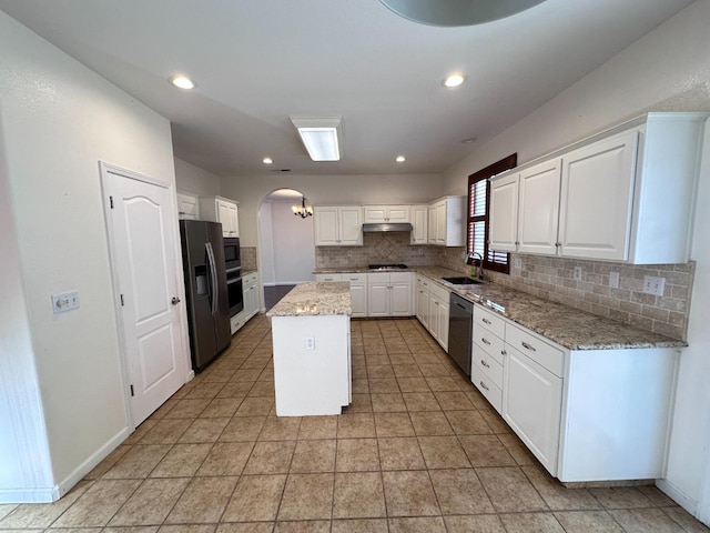 8352 N Shallot Way, Fresno, CA 93720 - kitchen featuring a center island, arched walkways, stainless steel appliances, backsplash, and under cabinet range hood