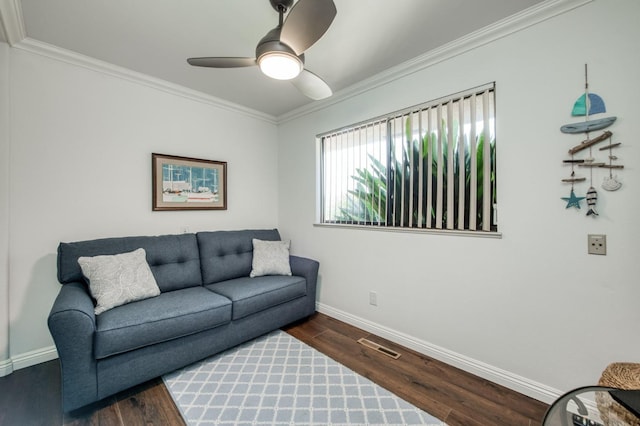 living area with baseboards, ornamental molding, and wood finished floors