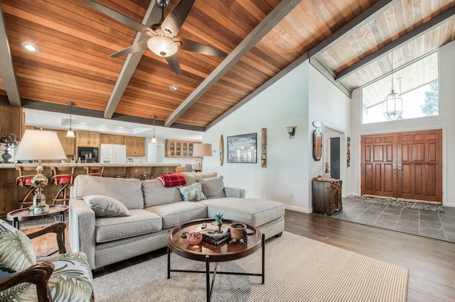 living room featuring ceiling fan with notable chandelier, wood ceiling, wood finished floors, baseboards, and beam ceiling