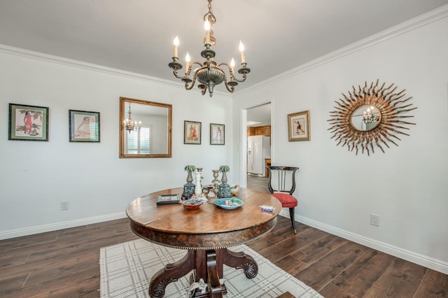 dining area featuring dark wood-type flooring, ornamental molding, baseboards, and a notable chandelier