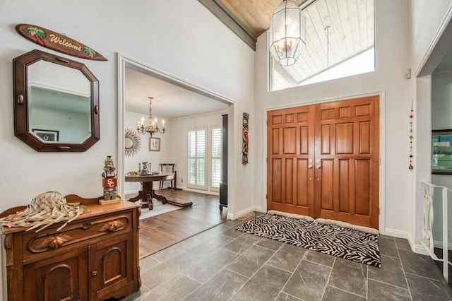 entryway with a chandelier, high vaulted ceiling, wood ceiling, and baseboards