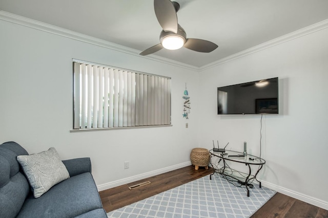 sitting room with ceiling fan, ornamental molding, visible vents, wood finished floors, and baseboards