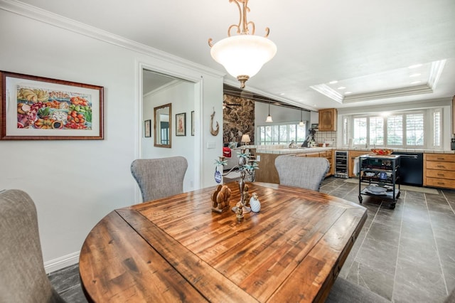 dining space with crown molding, a tray ceiling, and beverage cooler