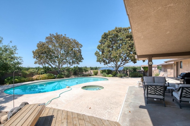 outdoor pool featuring area for grilling, a patio area, and an in ground hot tub