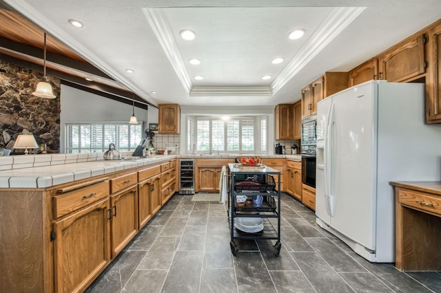 kitchen with a tray ceiling, white refrigerator with ice dispenser, a peninsula, wine cooler, and built in microwave