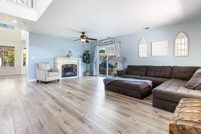 3232 Greenfield Ave, Clovis, CA 93611 - living area featuring a ceiling fan, light wood-type flooring, and a lit fireplace