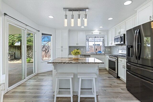 3232 Greenfield Ave, Clovis, CA 93611 - kitchen featuring stainless steel appliances, healthy amount of natural light, light stone countertops, recessed lighting, and decorative backsplash