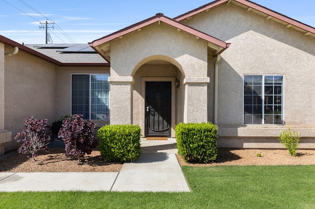 683 W Forest St, Kingsburg, CA 93631 - entrance to property featuring stucco siding, a yard, and solar panels