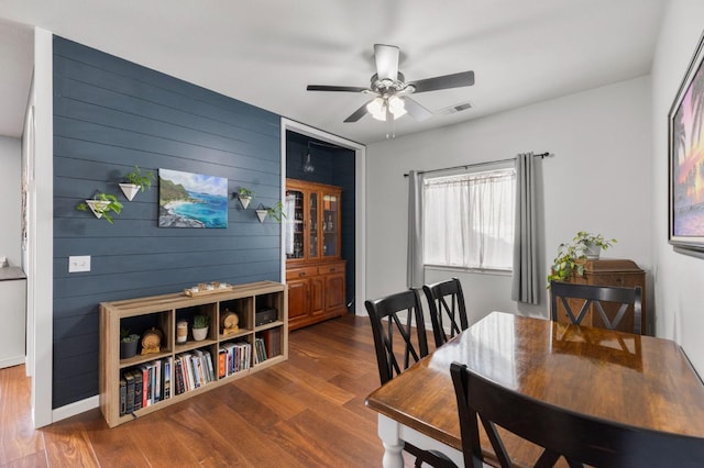 683 W Forest St, Kingsburg, CA 93631 - dining space featuring visible vents, a ceiling fan, wood finished floors, and wooden walls