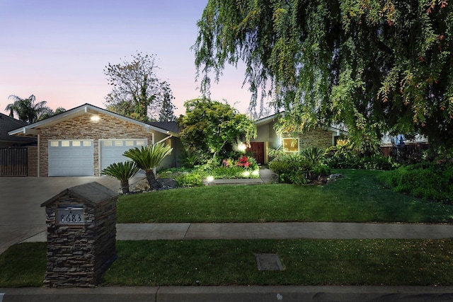 8683 N Colfax Ave, Fresno, CA 93720 - view of front of property featuring driveway, a garage, fence, a front lawn, and stone siding