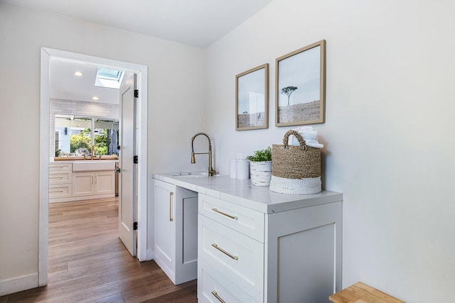 8683 N Colfax Ave, Fresno, CA 93720 - bar with a sink, recessed lighting, baseboards, wood finished floors, and a skylight