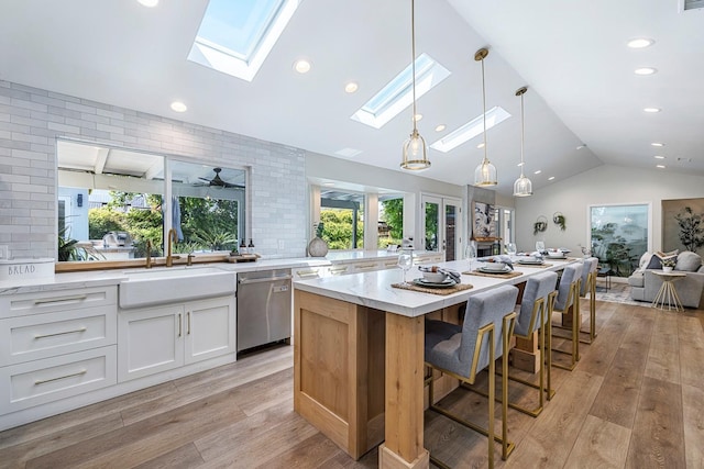 8683 N Colfax Ave, Fresno, CA 93720 - kitchen featuring a sink, light wood-style floors, lofted ceiling with skylight, and dishwasher