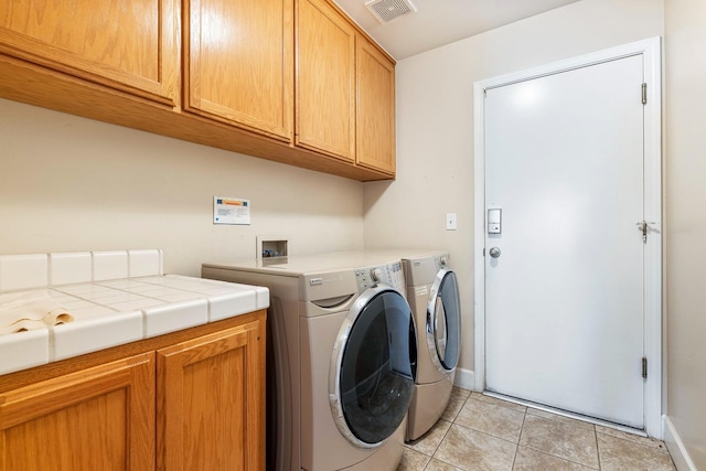 6187 W Alluvial Ave, Fresno, CA 93722 - washroom featuring cabinet space, light tile patterned flooring, and independent washer and dryer